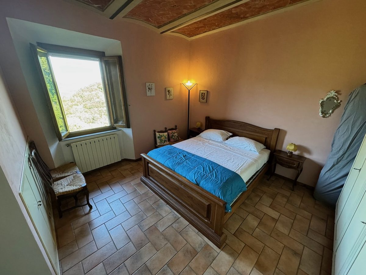 Schlafzimmer mit Doppelbett und Terrakottaboden